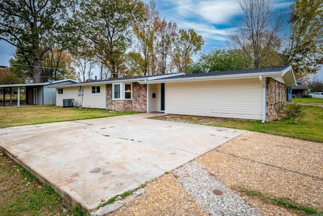 view of front of house featuring a front lawn, cooling unit, and a carport