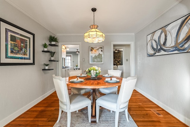 dining room featuring dark hardwood / wood-style flooring and crown molding