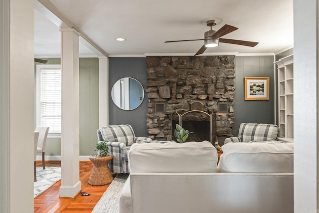 living room featuring ceiling fan, crown molding, a fireplace, and parquet flooring