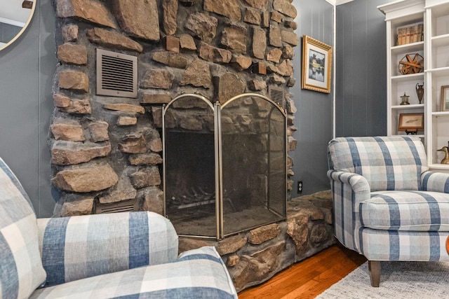 sitting room featuring hardwood / wood-style floors and a stone fireplace