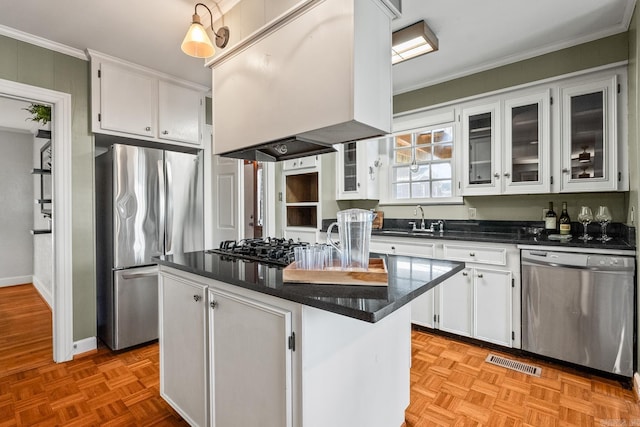 kitchen featuring white cabinets, appliances with stainless steel finishes, island range hood, and a kitchen island