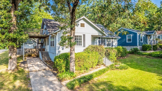 view of front of home with a front yard and a wooden deck