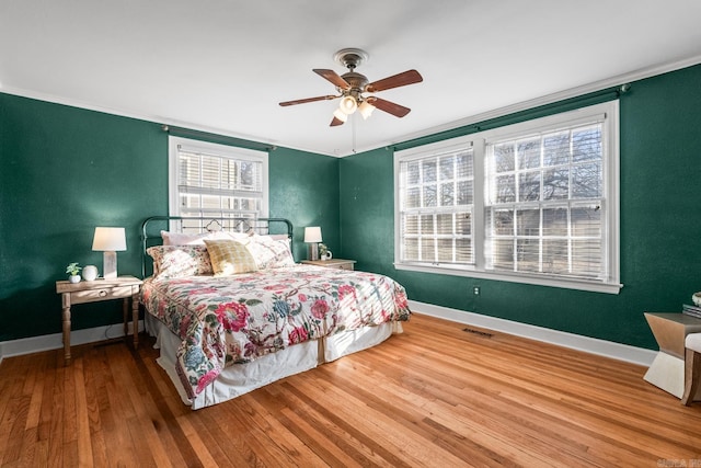 bedroom with ceiling fan, ornamental molding, and hardwood / wood-style floors