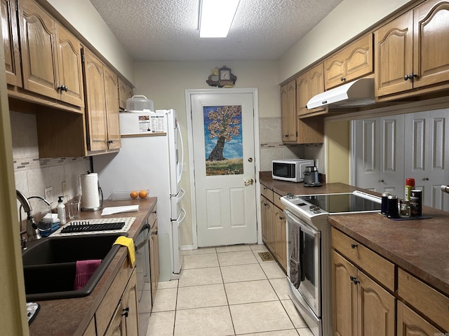 kitchen featuring white appliances, a textured ceiling, decorative backsplash, sink, and light tile patterned floors