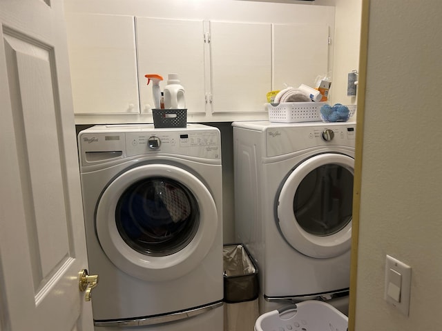 washroom with cabinets and washer and dryer