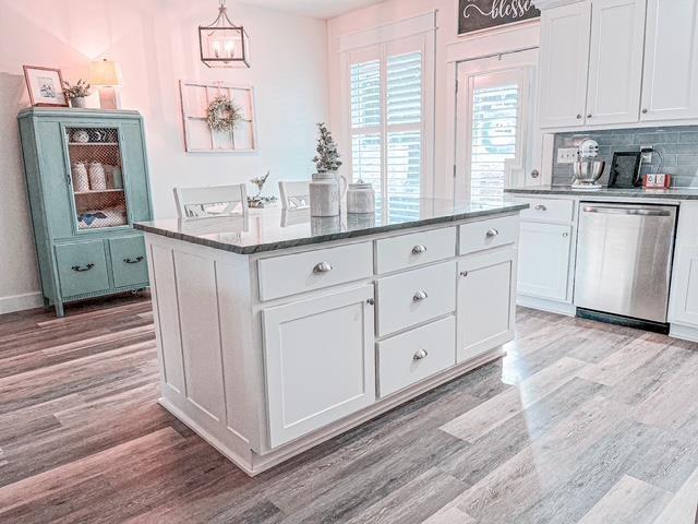 kitchen with white cabinets, dishwasher, and a center island