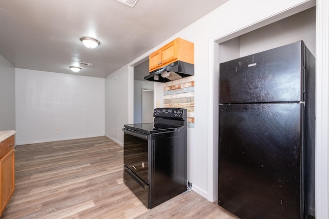 kitchen with light hardwood / wood-style floors, light brown cabinetry, and black appliances