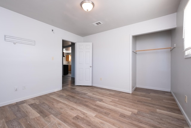 unfurnished bedroom featuring a closet and hardwood / wood-style floors