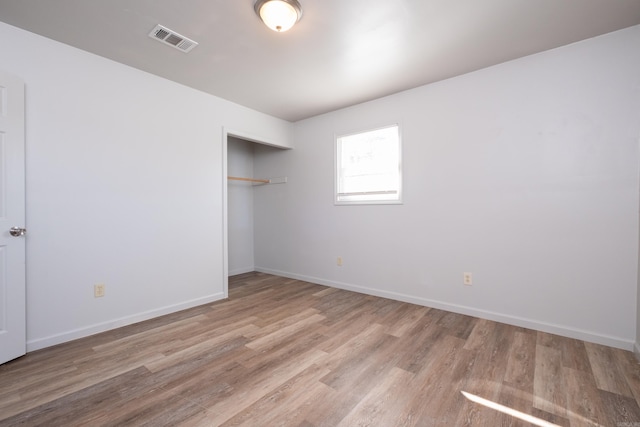 unfurnished bedroom with a closet and light hardwood / wood-style floors