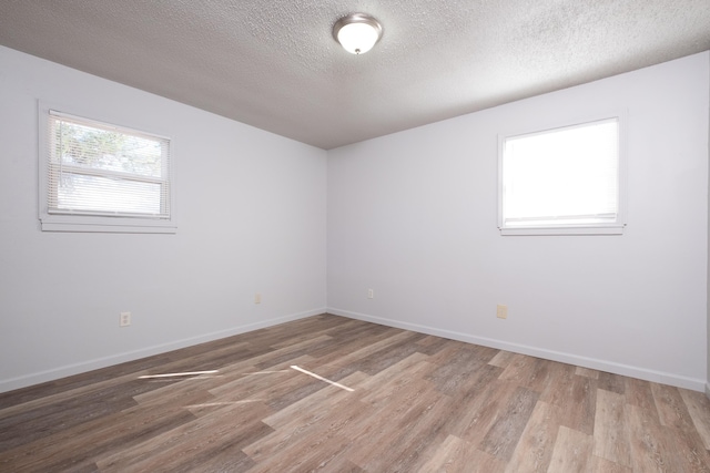 unfurnished room with a textured ceiling and hardwood / wood-style flooring