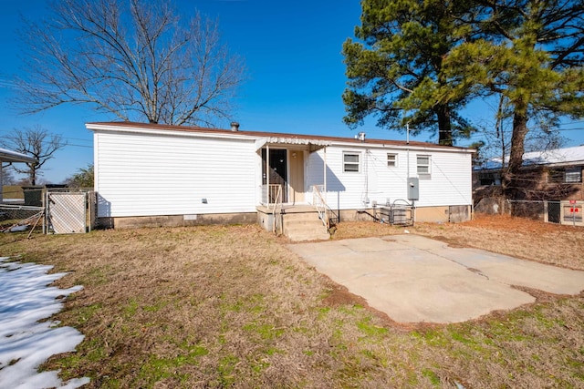 back of property featuring a patio area and a yard