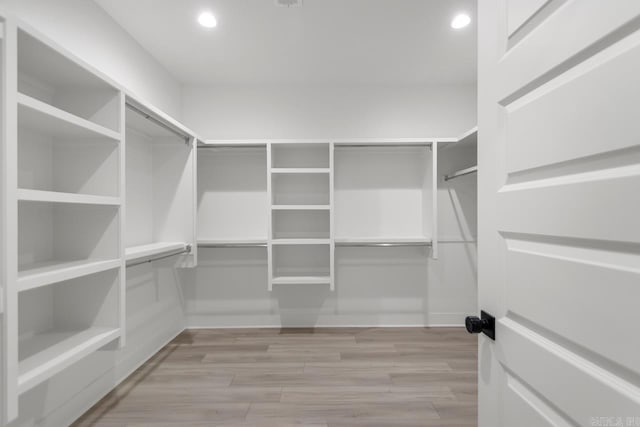 walk in closet with light hardwood / wood-style flooring