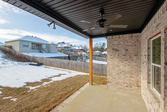 yard covered in snow featuring ceiling fan and a patio