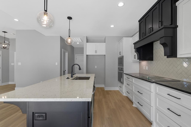 kitchen with sink, hanging light fixtures, backsplash, and black electric cooktop