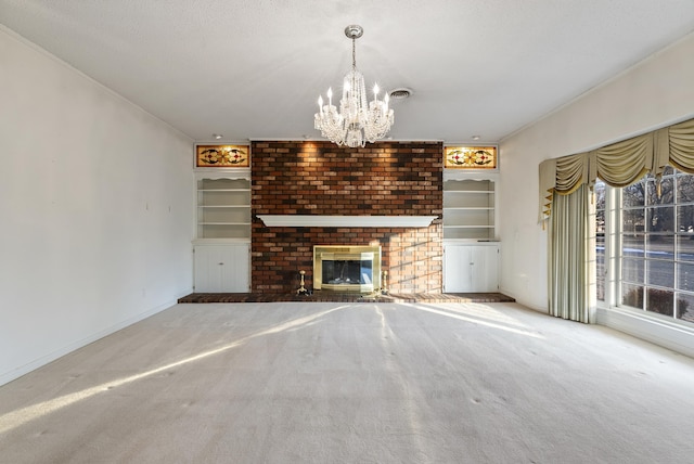 unfurnished living room with a fireplace, a notable chandelier, carpet flooring, built in features, and a textured ceiling