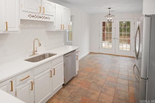 kitchen with stainless steel appliances, french doors, hanging light fixtures, white cabinets, and sink