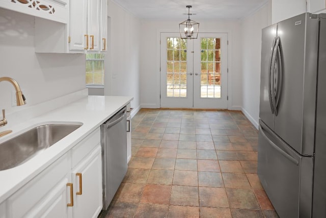 kitchen with decorative light fixtures, sink, appliances with stainless steel finishes, white cabinets, and french doors