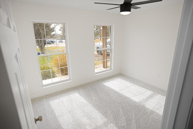 empty room featuring ceiling fan and carpet