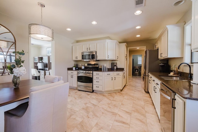 kitchen featuring stainless steel appliances, pendant lighting, white cabinets, and sink