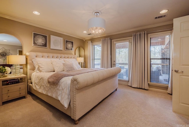 carpeted bedroom with ornamental molding and a chandelier