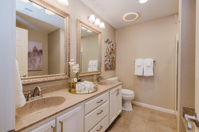 bathroom with toilet, vanity, and tile patterned floors