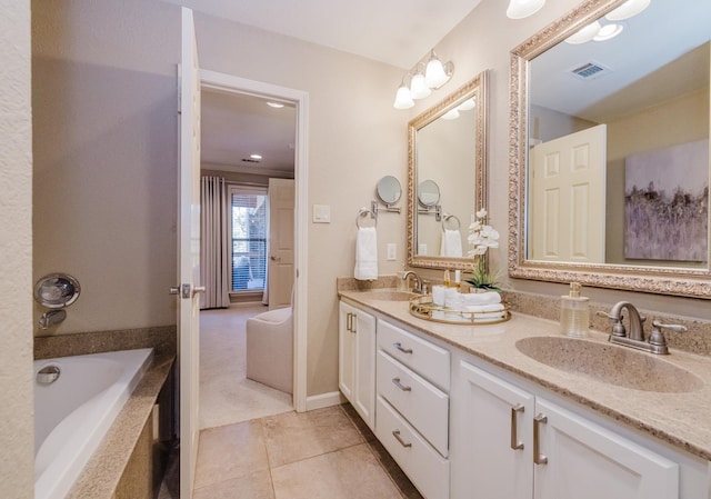 bathroom featuring tile patterned floors, tiled tub, and vanity