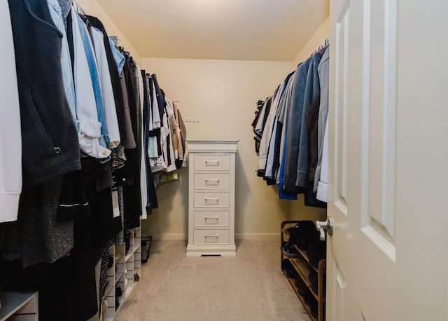 walk in closet with light carpet