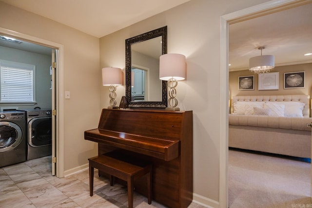 miscellaneous room featuring a notable chandelier and separate washer and dryer