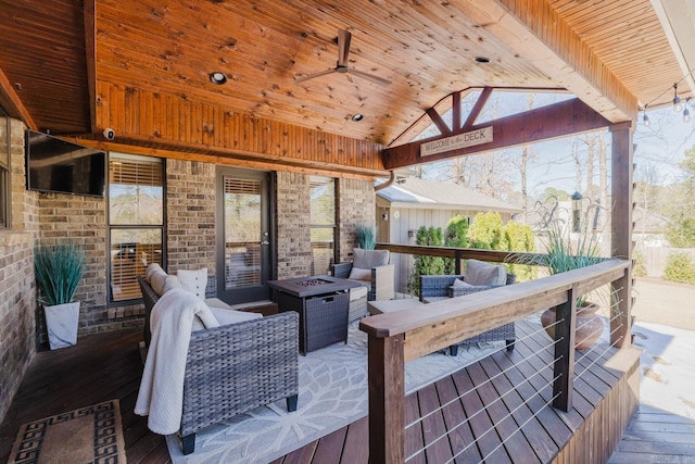 wooden deck with ceiling fan, an outdoor fire pit, a gazebo, and a bar