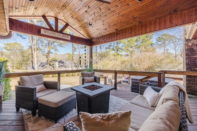 deck featuring an outdoor living space with a fire pit