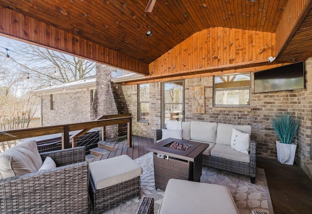 wooden terrace featuring an outdoor living space with a fire pit