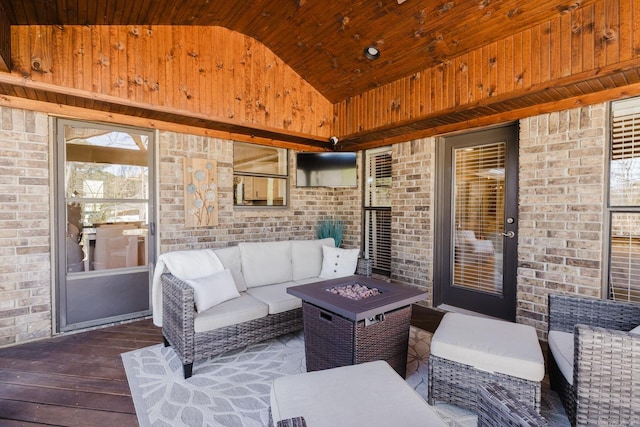 view of patio / terrace featuring a wooden deck and an outdoor living space with a fire pit