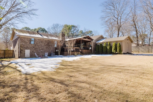 rear view of property featuring a storage shed and a yard