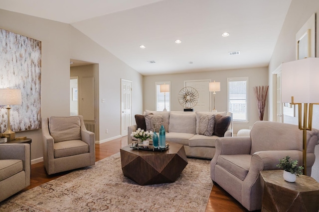 living room with vaulted ceiling, dark wood-type flooring, and a healthy amount of sunlight