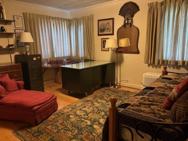 living area with light wood-type flooring and crown molding