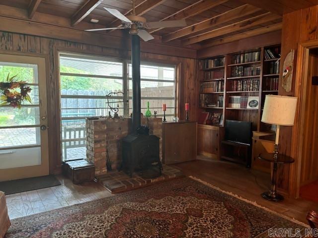 interior space featuring wood walls, a wood stove, and wooden ceiling