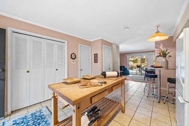 tiled dining room featuring crown molding