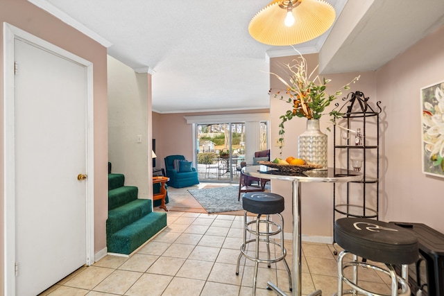 dining space with light tile patterned floors and crown molding