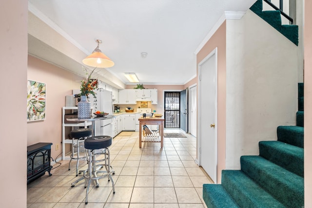 kitchen with stove, light tile patterned floors, white cabinets, and hanging light fixtures