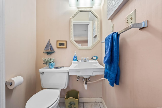 bathroom with toilet, tile patterned flooring, and sink