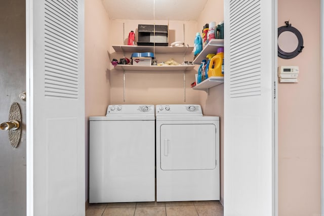 clothes washing area with a textured ceiling, light tile patterned flooring, and washer and dryer