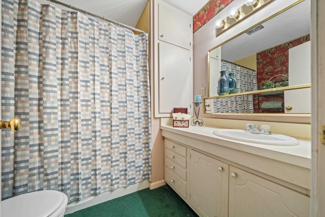 bathroom featuring a textured ceiling, toilet, and vanity