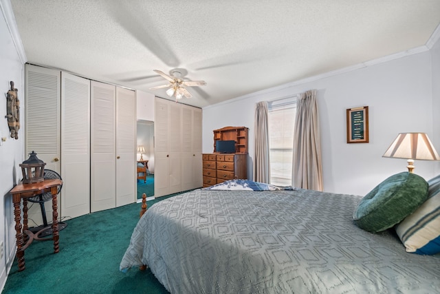 carpeted bedroom with a textured ceiling, ceiling fan, ornamental molding, and multiple closets