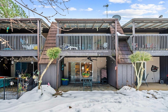 snow covered property featuring ceiling fan and a balcony