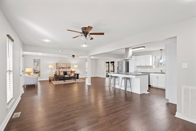 unfurnished living room featuring ceiling fan, dark hardwood / wood-style flooring, and sink