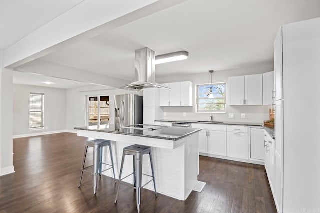 kitchen featuring white cabinetry, island exhaust hood, appliances with stainless steel finishes, hanging light fixtures, and a kitchen island