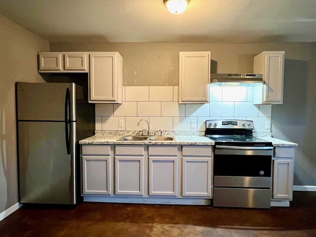 kitchen with light stone countertops, white cabinets, appliances with stainless steel finishes, decorative backsplash, and sink