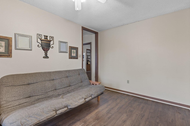 living area featuring a textured ceiling and dark hardwood / wood-style flooring