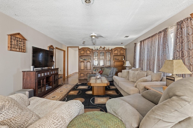 living room with ceiling fan, a textured ceiling, and hardwood / wood-style flooring