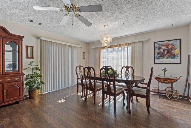 dining area with ceiling fan with notable chandelier, a textured ceiling, and dark hardwood / wood-style flooring